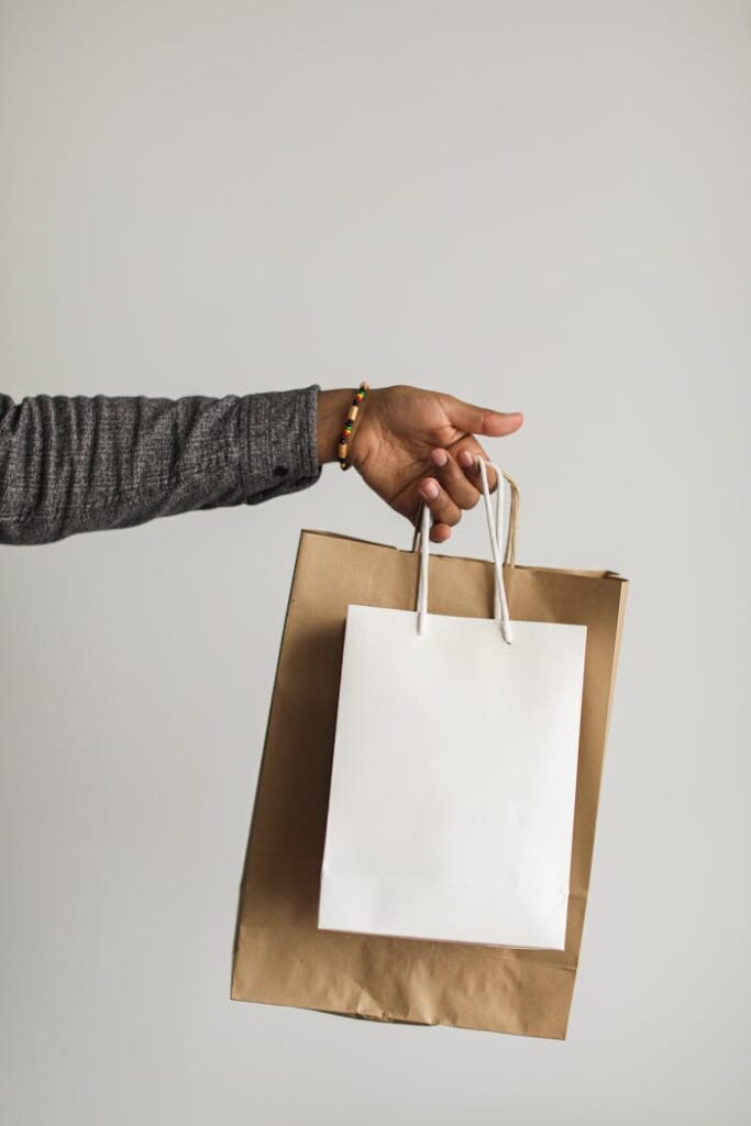 person-holding-white-shopping-bag-and-brown-paper-bag-6956890
